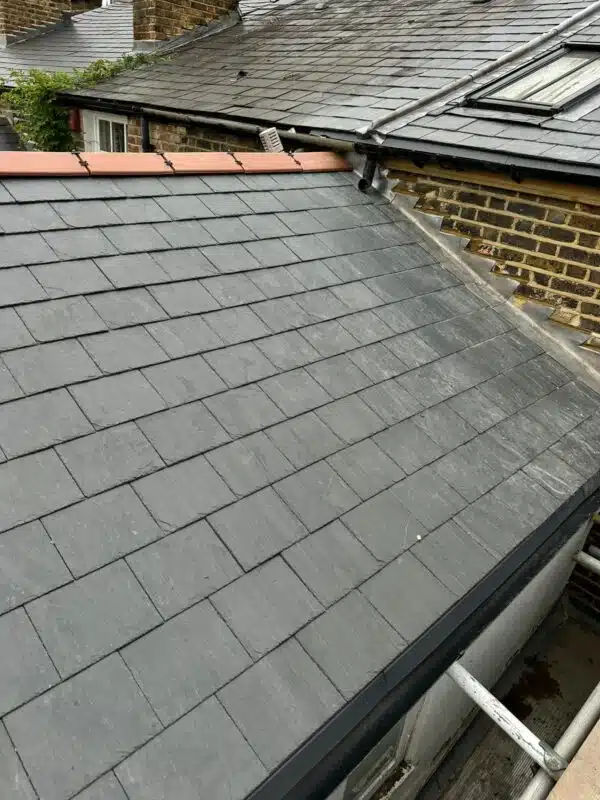 Completed slate roof finished with terracotta ridge tiles