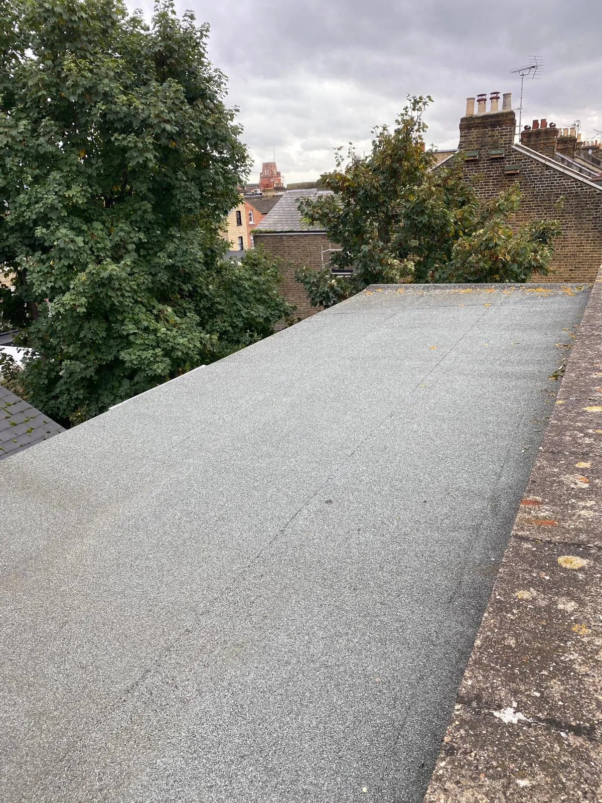 Mineral felt flat roof finished up to a brick parapet wall
