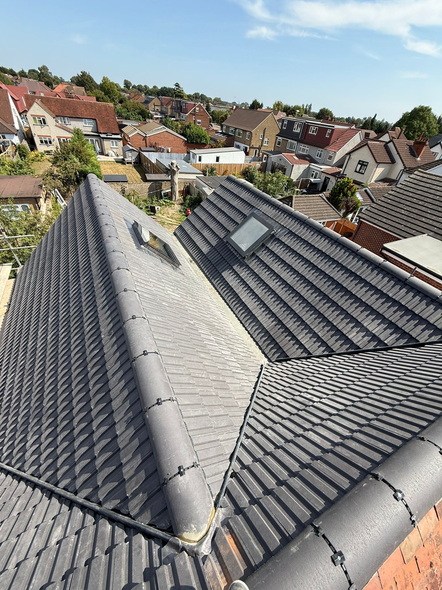 Completed interlocking tile roof with a dry ridge system, lead valley and two skylights