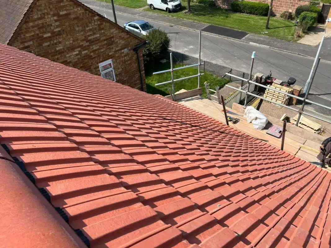 Newly laid terracotta-tile roof with scaffolding alongside the house