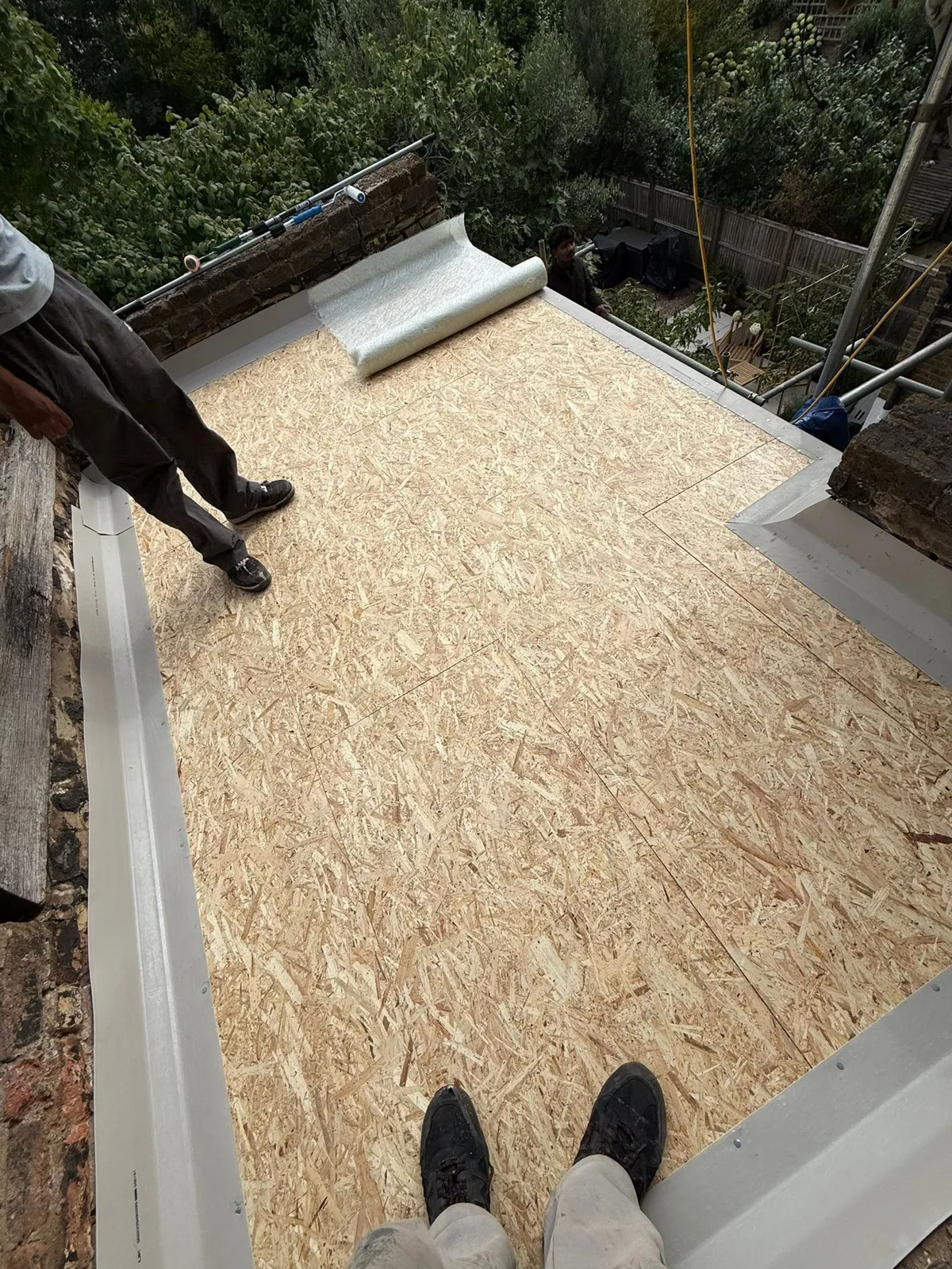 New OSB deck boards being laid and prepared on a flat roof ready for a GRP fibreglass covering
