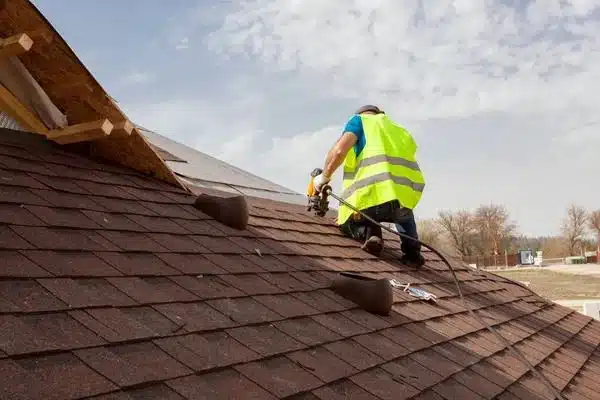 New brown shingle roof covering being installed