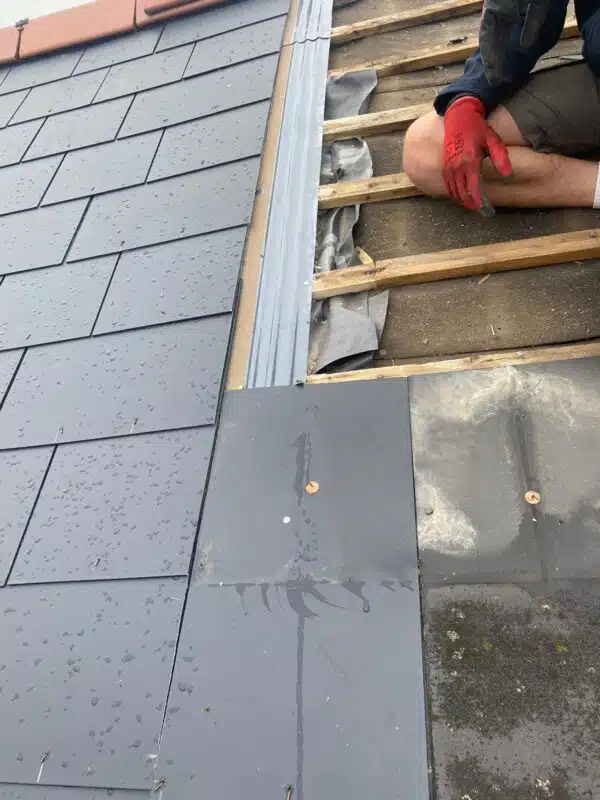 Slate roof repair with new metal flashing and fresh battens