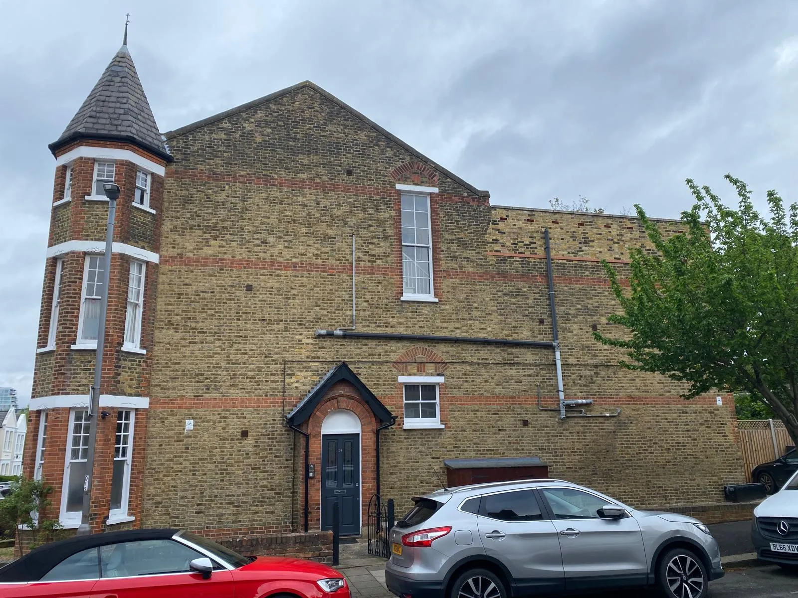 Overview of a Victorian slate roof with turret and chimneys after inspection